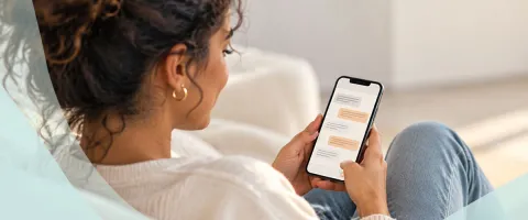 Woman relaxing, texting on smartphone in cozy room.