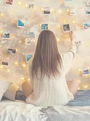 Girl sitting on her bed in her room, watching photos