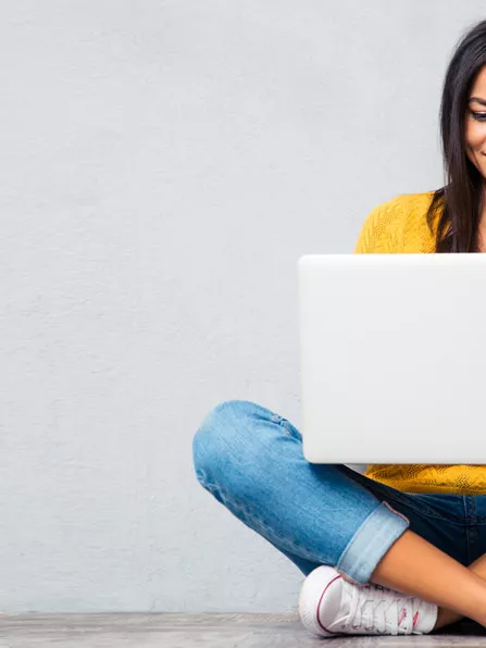 Frau mit Laptop auf dem Schoß